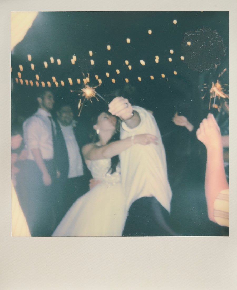 Instant wedding photo of the bride and groom dancing with sparklers
